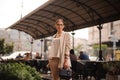 Pretty young brunette woman dressed casual posing outdoor with leather handbag Royalty Free Stock Photo