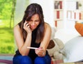 Pretty young brunette woman holding pregnancy home test, touching head with hand and looking depressed, bookshelves Royalty Free Stock Photo