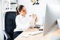Pretty young buinesswoman making notes while sitting at workplace Royalty Free Stock Photo