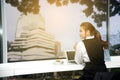 Pretty young business Asian woman is working a laptop sitting in a building. Royalty Free Stock Photo