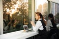 Pretty young business Asian woman is working a laptop sitting in a building. Royalty Free Stock Photo