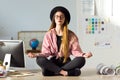 Pretty young business woman doing yoga on the table in the office. Royalty Free Stock Photo