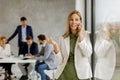 Young business woman standing in the office and using mobile phone in front of her team Royalty Free Stock Photo