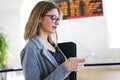 Pretty young business woman using her mobile phone in the train station. Royalty Free Stock Photo