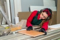 Pretty and young carpentry worker sawing wooden plank Royalty Free Stock Photo