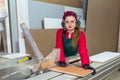 Pretty and young carpentry worker sawing wooden plank Royalty Free Stock Photo