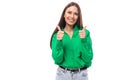 pretty young caucasian brunette lady with makeup dressed in a green shirt and jeans posing on a white background with Royalty Free Stock Photo