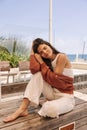 Pretty young caucasian girl posing with closed eyes sits on bench outdoor. Royalty Free Stock Photo