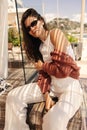 Pretty young caucasian girl posing, sitting on bench near beach on warm day. Royalty Free Stock Photo