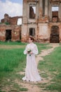 Pretty young caucasian redhead girl in a garden and outside with her wedding bouquet. Beautiful redhead bride Royalty Free Stock Photo