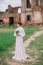 Pretty young caucasian redhead girl in a garden and outside with her wedding bouquet. Beautiful redhead bride Royalty Free Stock Photo