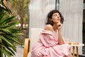 Pretty young caucasian woman breathes fresh air with her eyes closed sitting on terrace. Royalty Free Stock Photo