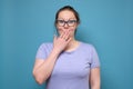 Pretty young caucasian woman with glasses with hand over mouth