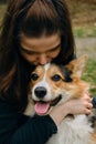 A pretty young Caucasian woman hugs and kisses her dog while walking in the park. Portrait of the owner with a pet in Royalty Free Stock Photo