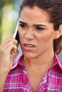 Young Diverse Adult Female Using Cell Phone And Unhappy Wearing Pink Shirt Royalty Free Stock Photo