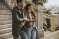 Young couple smiling and talking while strolling down outdoor stairs on autumn day Royalty Free Stock Photo