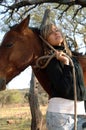 Pretty young cowgirl with a horse Royalty Free Stock Photo