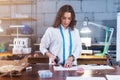 Pretty young fashion designer cutting cloth using scissors while working in studio Royalty Free Stock Photo