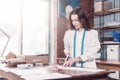 Pretty young fashion designer cutting cloth using scissors while working in studio Royalty Free Stock Photo