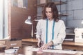 Pretty young fashion designer cutting cloth using scissors while working in studio Royalty Free Stock Photo