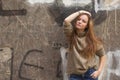 Pretty young fashion girl standing near a stone wall Royalty Free Stock Photo