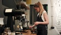 Pretty young female barista weighing coffee grains on a scale before brewing a cup of coffee Royalty Free Stock Photo