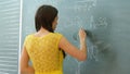 Pretty young female college student writing on the chalkboard blackboard during a chemistry class Royalty Free Stock Photo