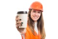 Pretty young female constructor offering cup of coffee