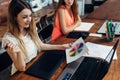 Pretty young female graphic designer looking at color chart sitting at desk in her office Royalty Free Stock Photo