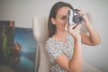 Pretty, young female photographer in her studio taking photos with a vintage film camera Royalty Free Stock Photo