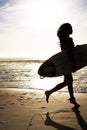 Pretty young female surfer with her surfboard. Young female running with a surfboard towards sea - Outdoor. Royalty Free Stock Photo