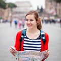 Pretty young female tourist holding a map