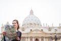 Pretty young female tourist studying a map