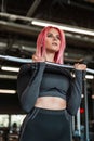 Pretty young fitness woman model in black sportswear working out with a bar in the gym Royalty Free Stock Photo