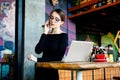 pretty young freelancer woman on coffee shop. Beautiful lady with smart phone in her hands using laptop Royalty Free Stock Photo