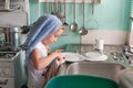 Pretty young girl drying dishes at the sink Royalty Free Stock Photo