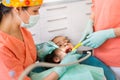 Dental checkup, being given to young girl, by female dentist with assistant Royalty Free Stock Photo