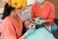 Dental checkup, being given to young girl, by female dentist with assistant Royalty Free Stock Photo