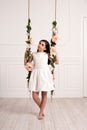 Pretty young girl on a floral decorated swing