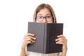 Pretty young girl in glasses hiding behind a black book Royalty Free Stock Photo