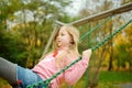 Pretty young girl having fun on a playground in beautiful autumn park. Cute preteen child playing outdoors in late autumn. Outdoor