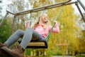 Pretty young girl having fun on a playground in beautiful autumn park. Cute preteen child playing outdoors in late autumn. Outdoor