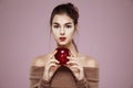 Pretty young girl holding red apple in hands looking at camera. Copy space. Royalty Free Stock Photo