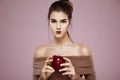 Pretty young girl holding red apple in hands looking at camera. Copy space. Royalty Free Stock Photo