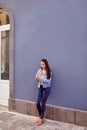 Pretty young girl leaning against a blue wall Royalty Free Stock Photo