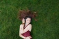 Pretty young girl listen music in headphones lying on grass Royalty Free Stock Photo