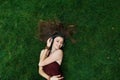 Pretty young girl listen music in headphones lying on grass Royalty Free Stock Photo
