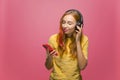 Pretty young girl listening to music on mobile phone with wired headphones enjoying sound. Musical apps advertising Royalty Free Stock Photo