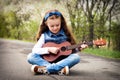 Pretty young girl playing ukulele in the park Royalty Free Stock Photo