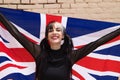 Pretty young girl in punk style with the london flag on her shoulders celebrating some national event. Patriotic concept